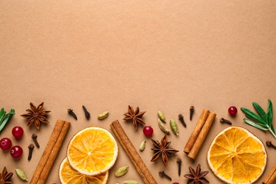 Different mulled wine ingredients on brown background, flat lay. Space for text