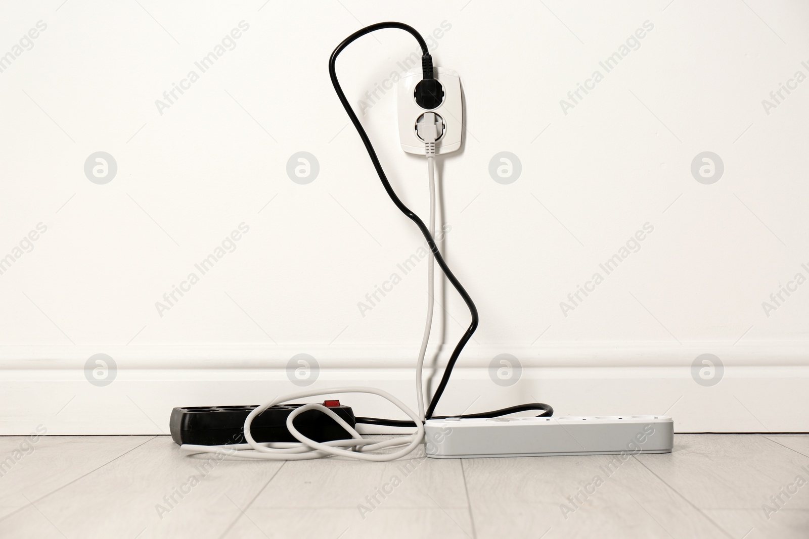 Photo of Extension cords with power plugs in socket indoors. Electrician's professional equipment