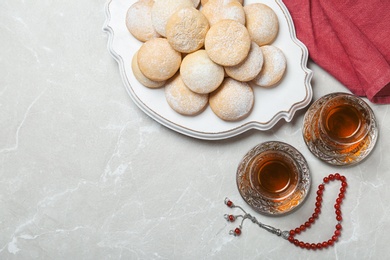 Flat lay composition with traditional Islamic cookies on table, space for text. Eid Mubarak