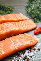 Photo of Fresh salmon and ingredients for marinade on wooden table, closeup