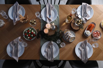 Christmas table setting with festive decor and dishware, top view