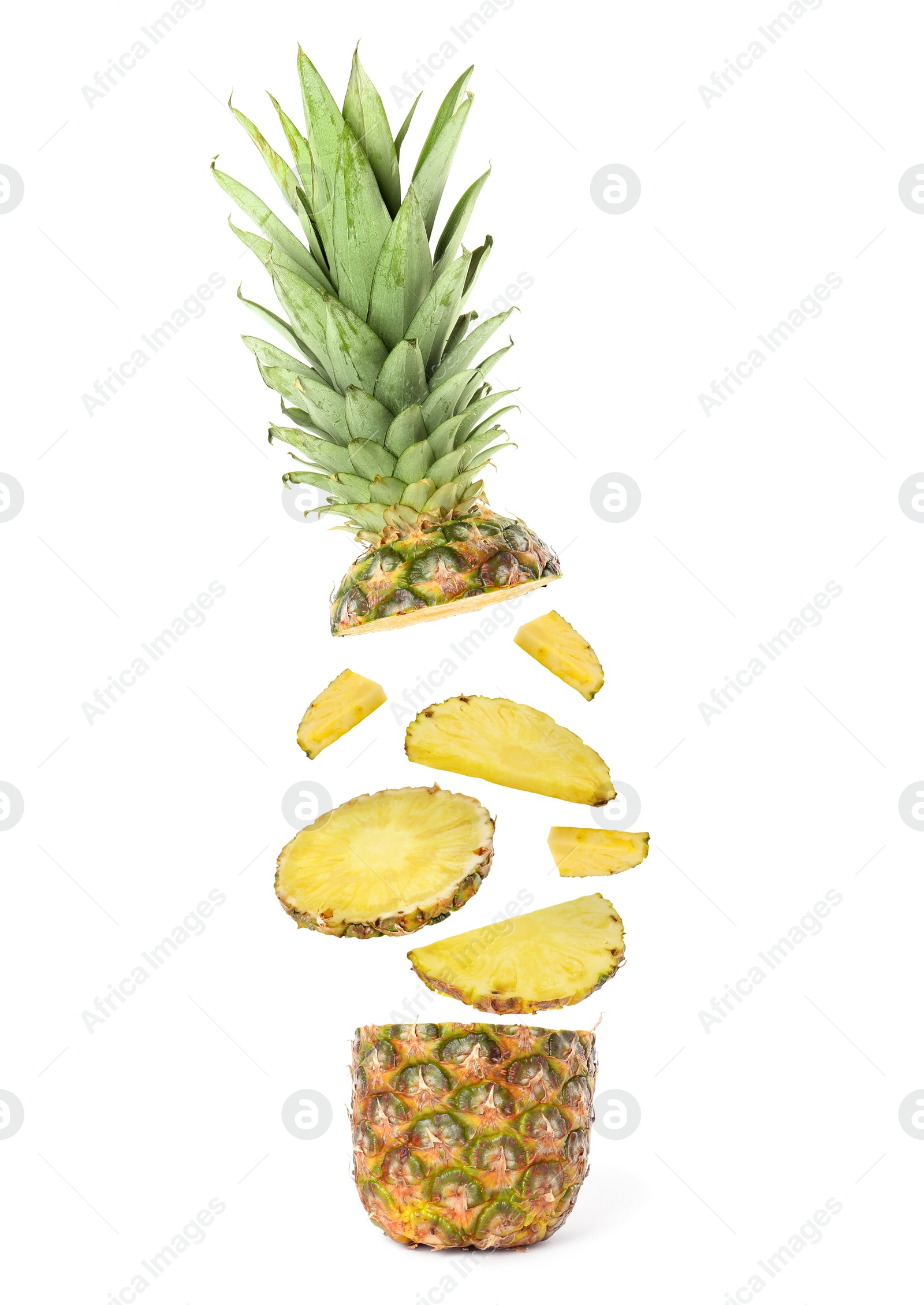 Image of Slices of juicy pineapple flying between its top and bottom on white background