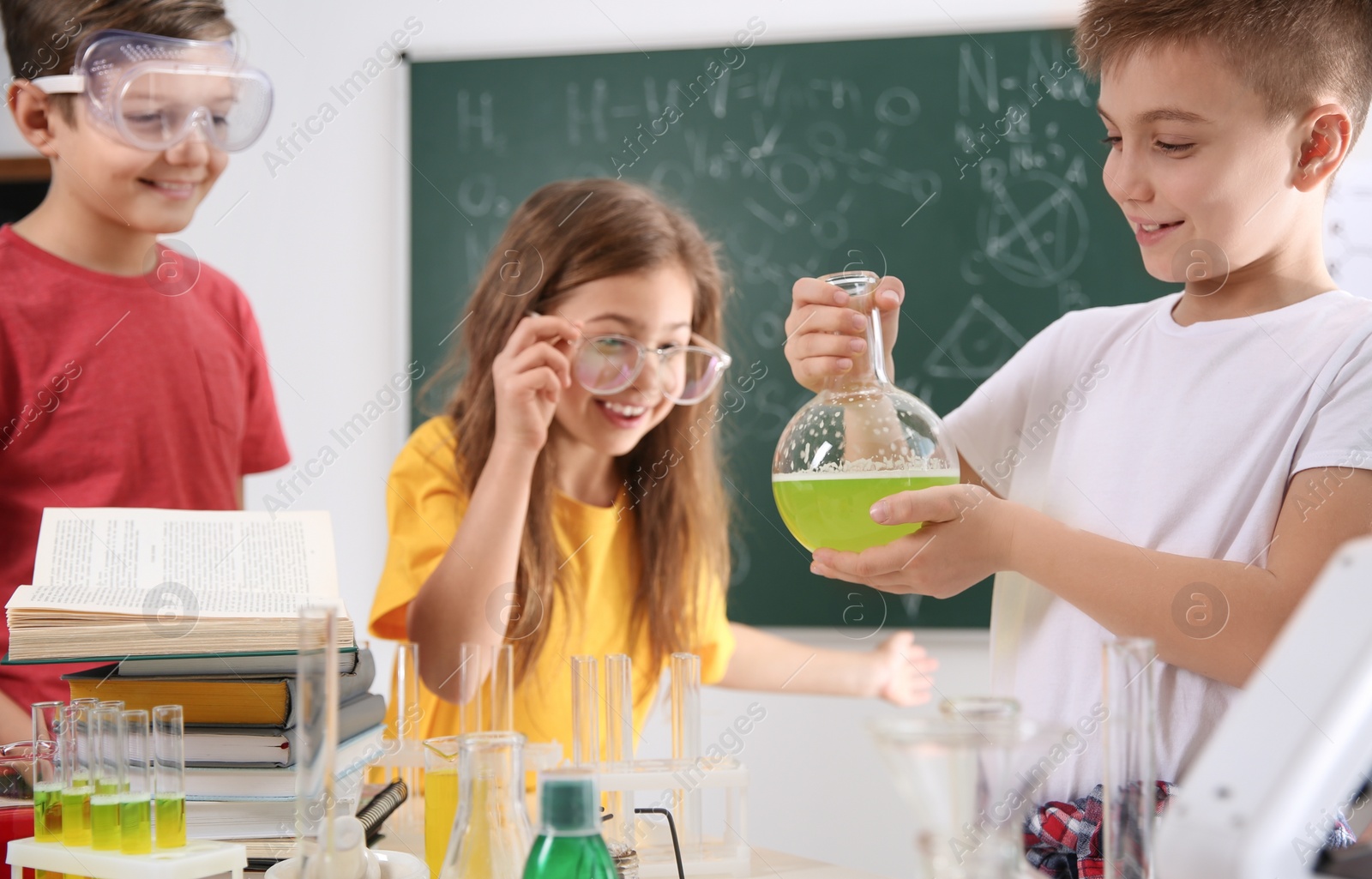 Photo of Smart pupils making experiment in chemistry class