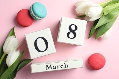 Photo of Wooden block calendar with date 8th of March, macarons and tulips on pink background, flat lay. International Women's Day