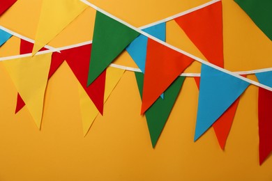 Photo of Buntings with colorful triangular flags on orange background