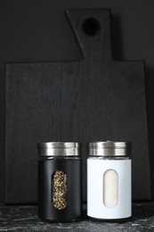 Salt and pepper shakers on dark table