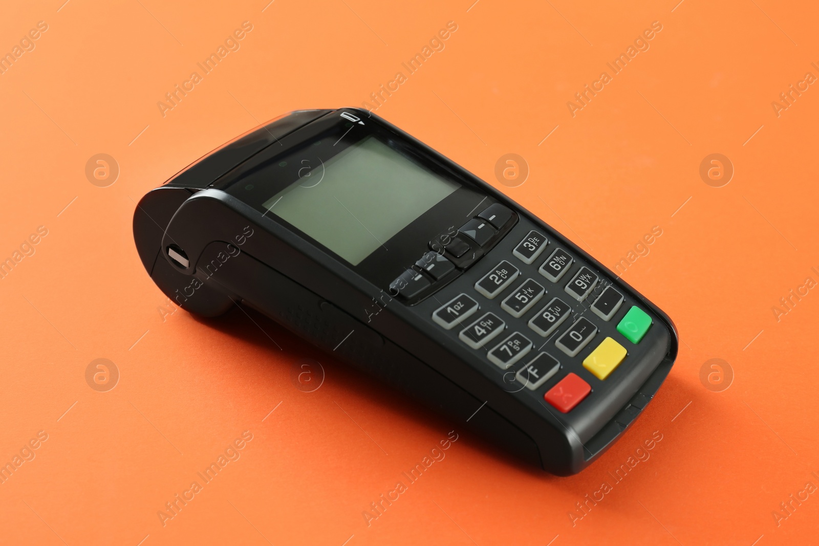 Photo of New modern payment terminal on orange background