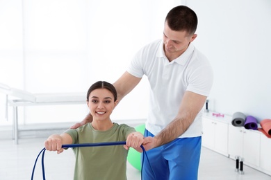 Professional physiotherapist working with female patient in rehabilitation center