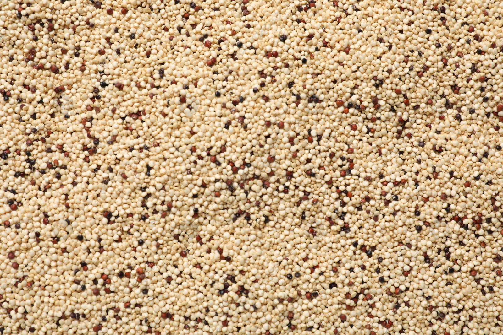 Photo of Raw quinoa seeds as background, top view