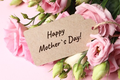 Image of Happy Mother's Day greeting label and beautiful flowers on pink background