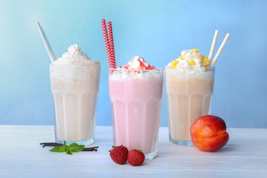 Photo of Glasses with delicious milk shakes on table