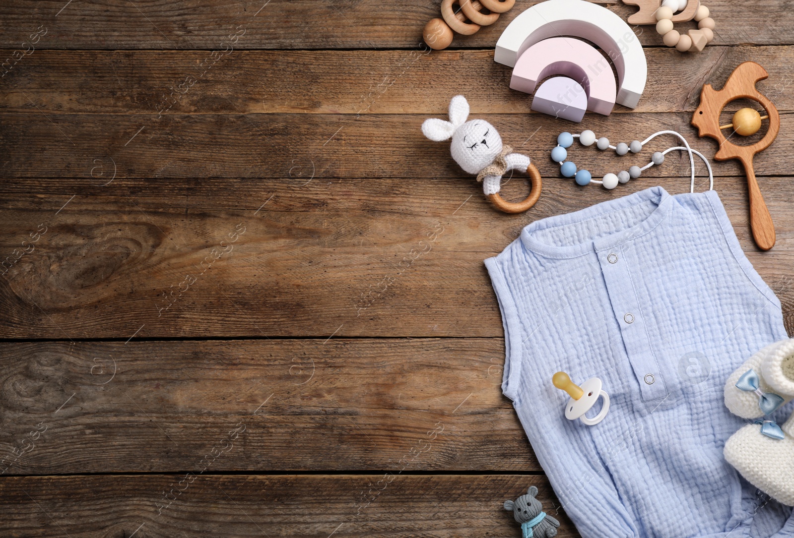 Photo of Flat lay composition with baby clothes and accessories on wooden background, space for text