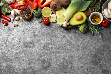 Flat lay composition with fresh products on grey table, space for text. Healthy cooking