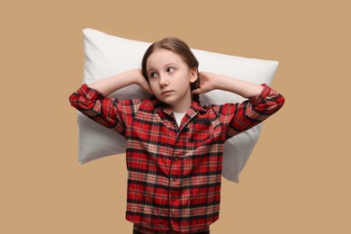 Photo of Sleepy girl with pillow on beige background. Insomnia problem