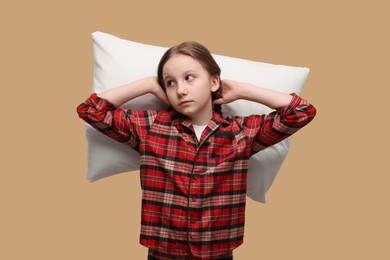 Sleepy girl with pillow on beige background. Insomnia problem