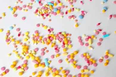 Many different pills on white background