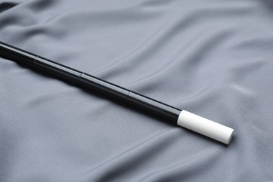 Photo of Beautiful black magic wand on grey fabric