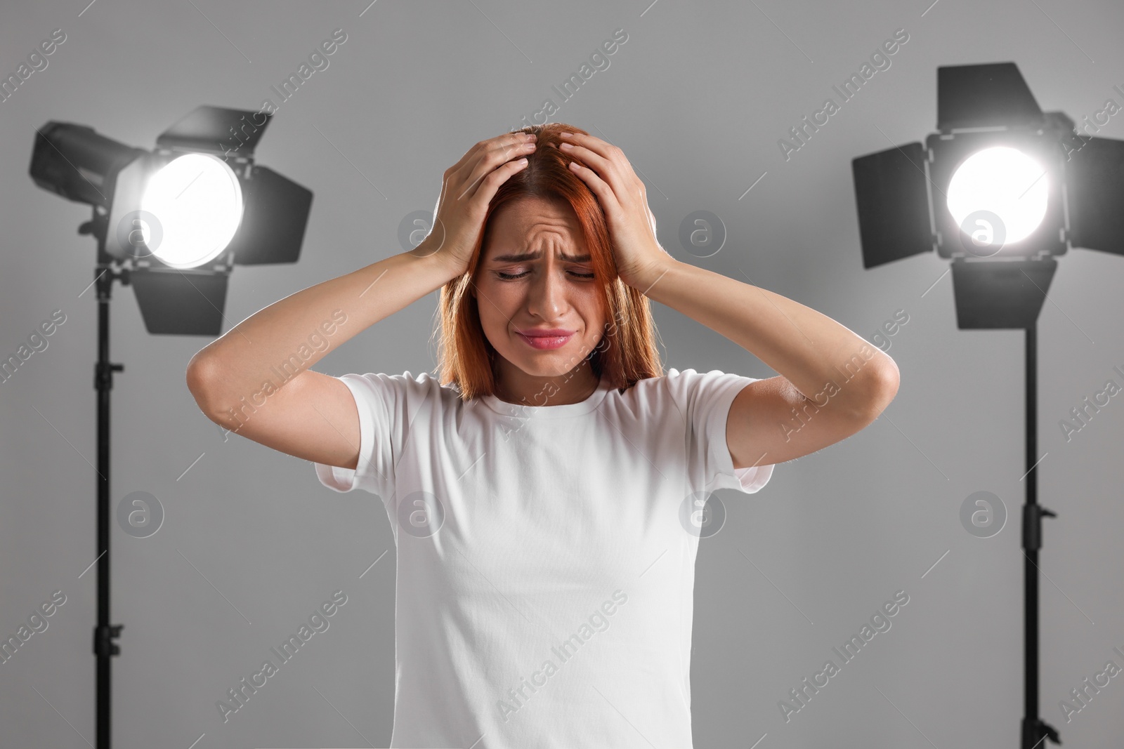 Photo of Casting call. Emotional woman performing on grey background in studio