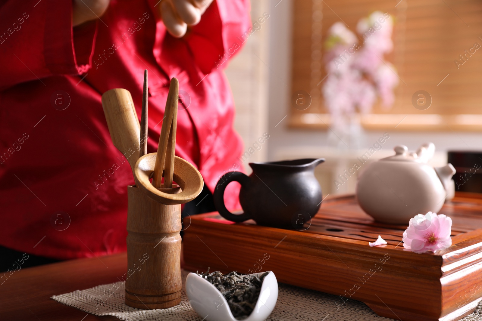 Photo of Traditional tea ceremony. Master near tray with tools, closeup