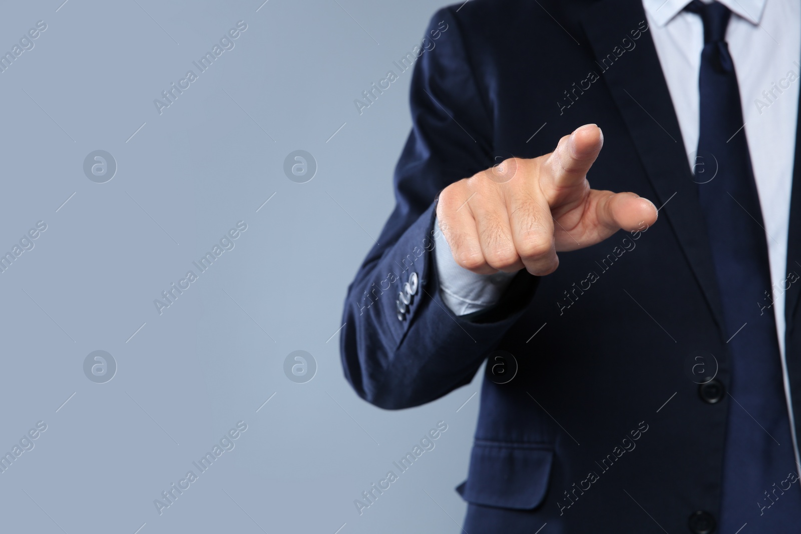 Photo of Businessman pointing on grey background, closeup view of hand with space for text