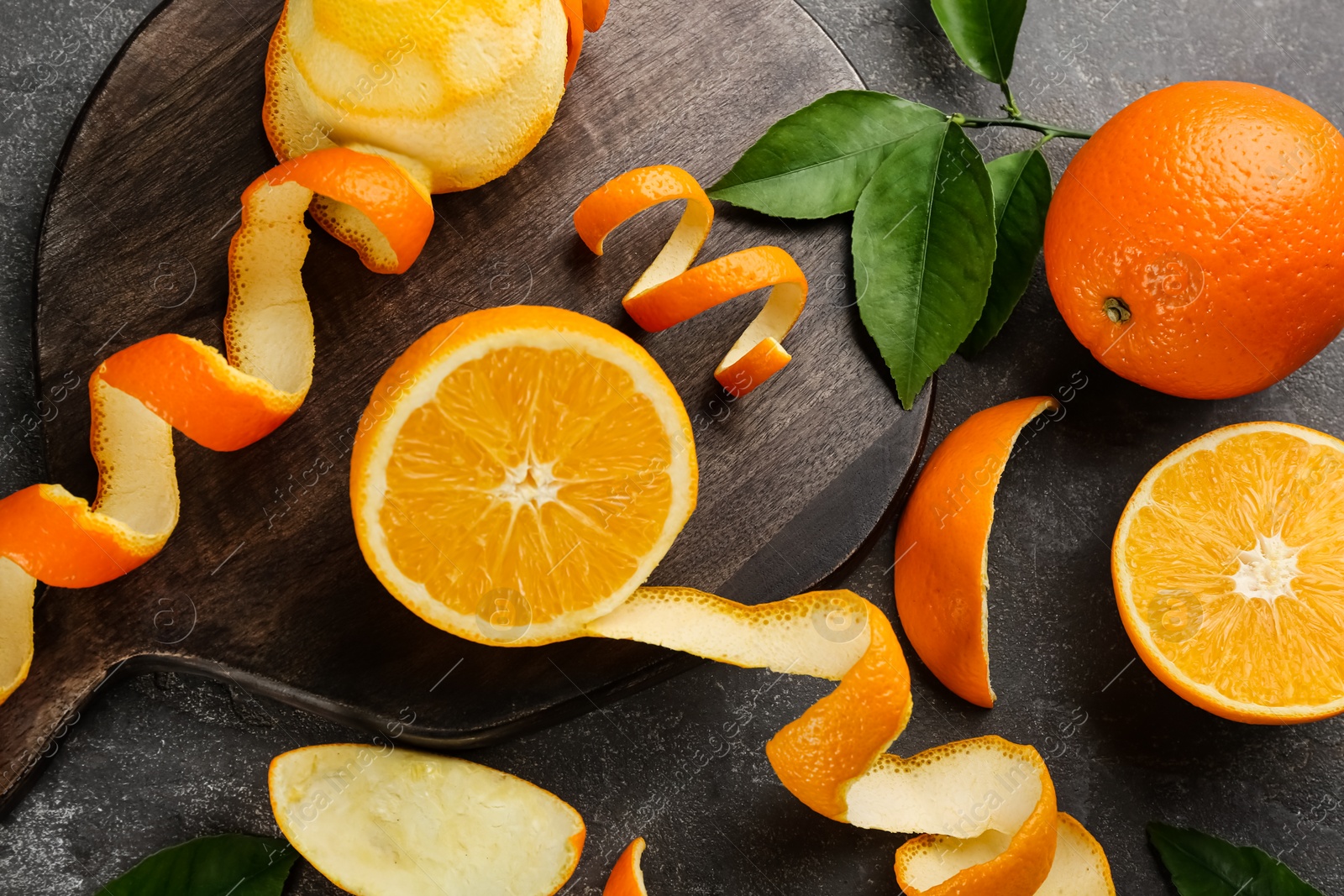 Photo of Dry orange fruits with peels on grey table, flat lay