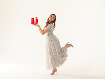 Beautiful woman with Christmas gift on white background