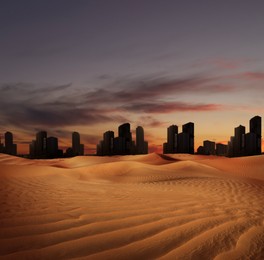Image of Sandy desert and silhouette of city on horizon in dusk