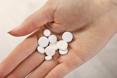 Photo of Woman holding many pills in hand, closeup view