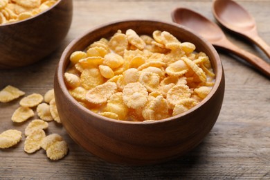Photo of Tasty cornflakes with milk served on wooden table, closeup