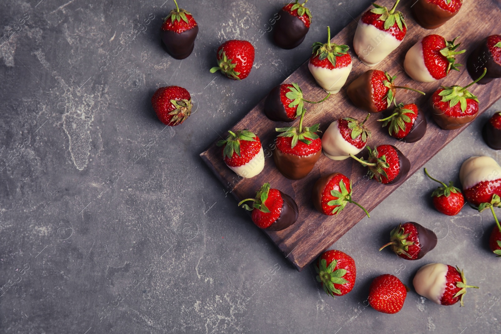 Photo of Flat lay composition with chocolate covered strawberries on grey background