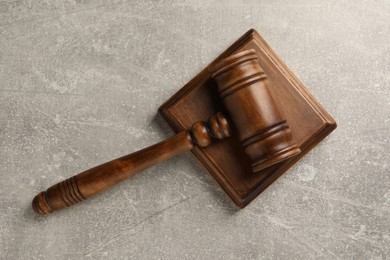 Wooden gavel on grey textured table, top view