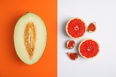 Photo of Flat lay composition with melon, grapefruit and fig on color background