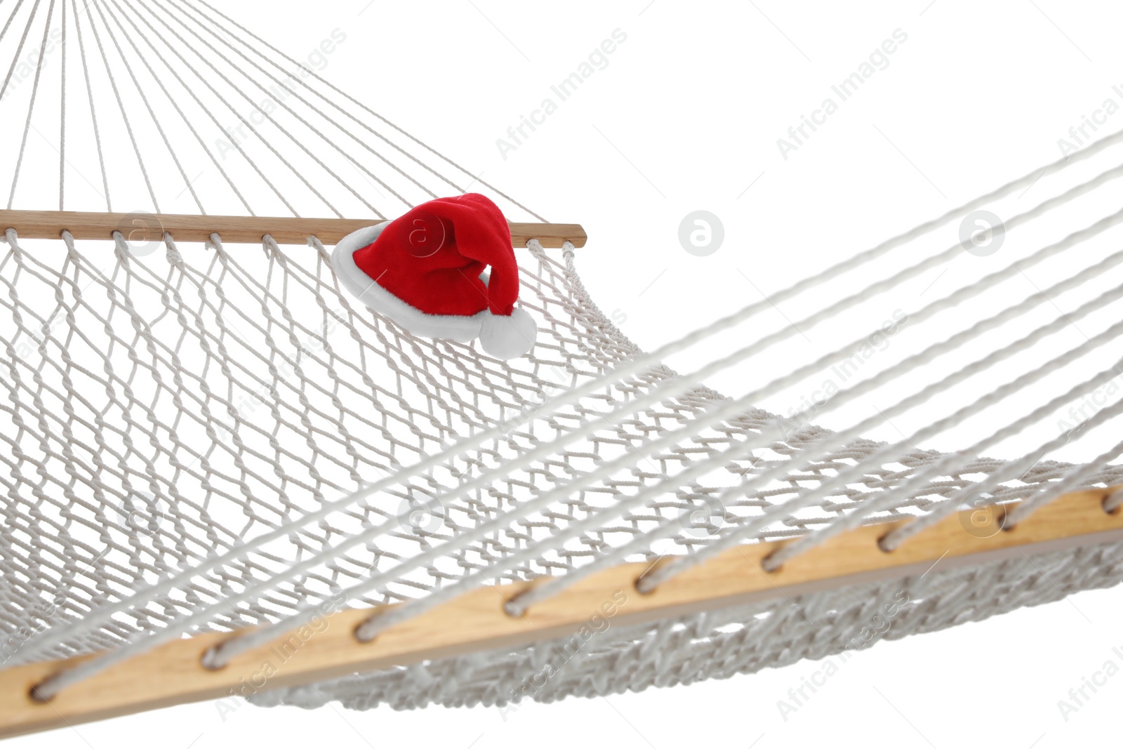 Photo of Comfortable hammock and Santa Claus hat on white background. Christmas vacation