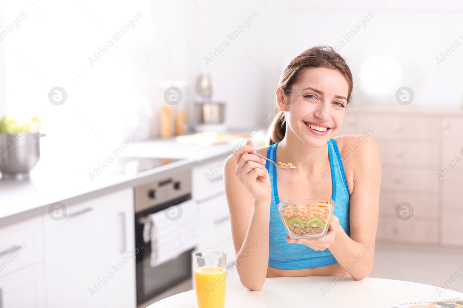 Photo of Young woman in fitness clothes having healthy breakfast at home. Space for text