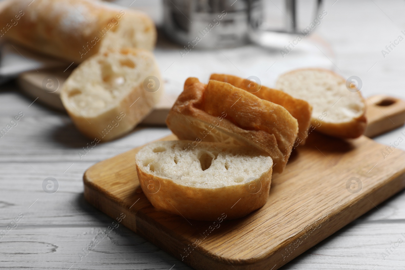 Photo of Fresh crispy ciabattas on white wooden table