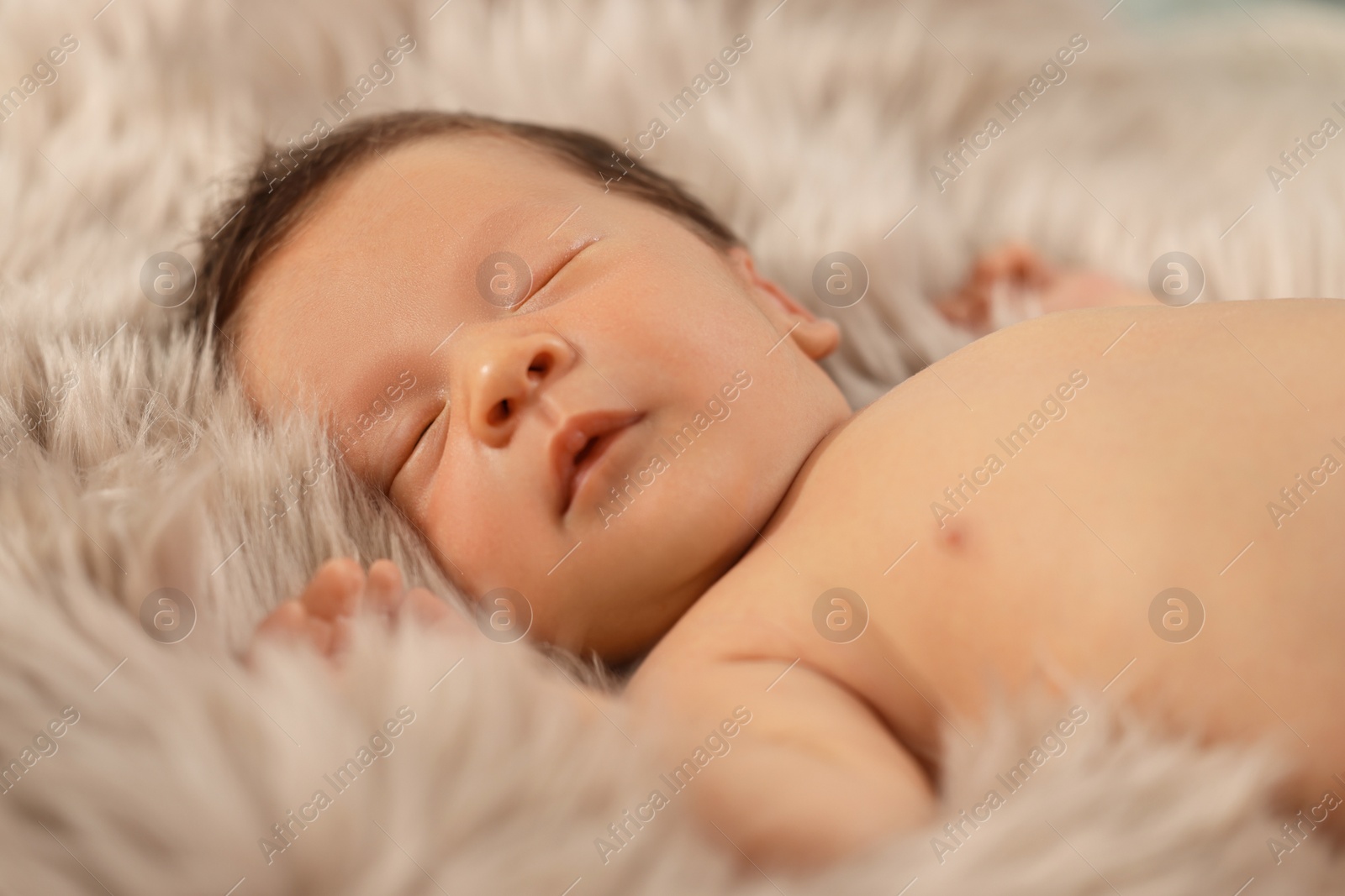 Photo of Cute newborn baby sleeping on fluffy blanket, closeup