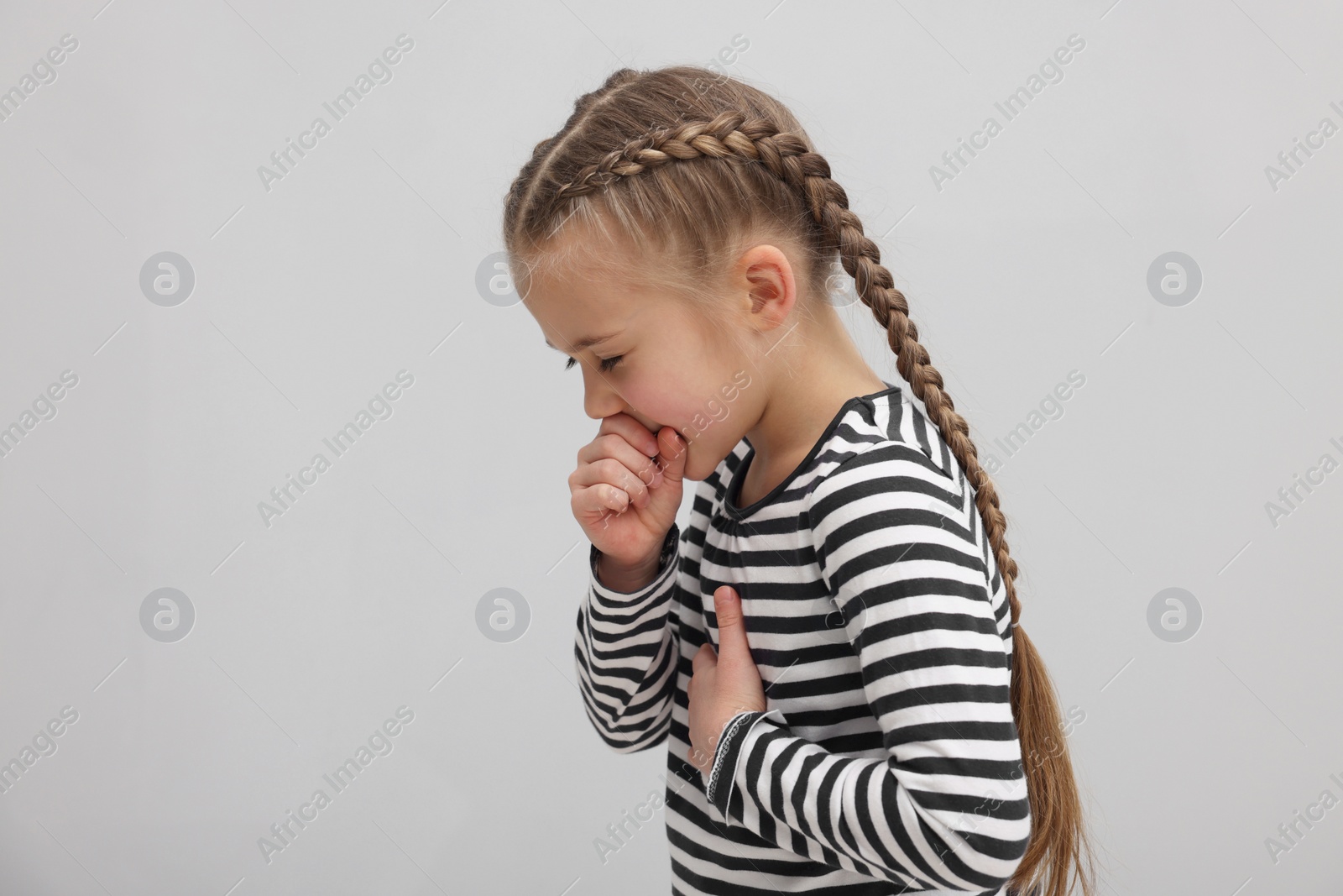 Photo of Sick girl coughing on gray background. Cold symptoms