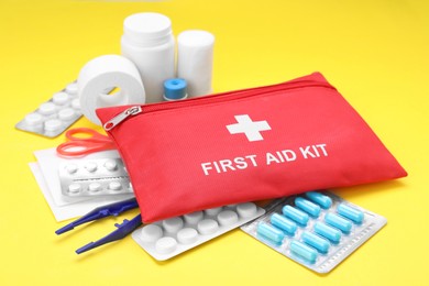 Photo of First aid kit on yellow background, closeup