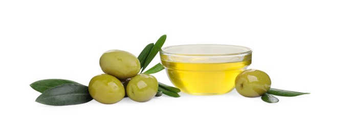 Photo of Cooking oil in glass bowl, olives and leaves on white background