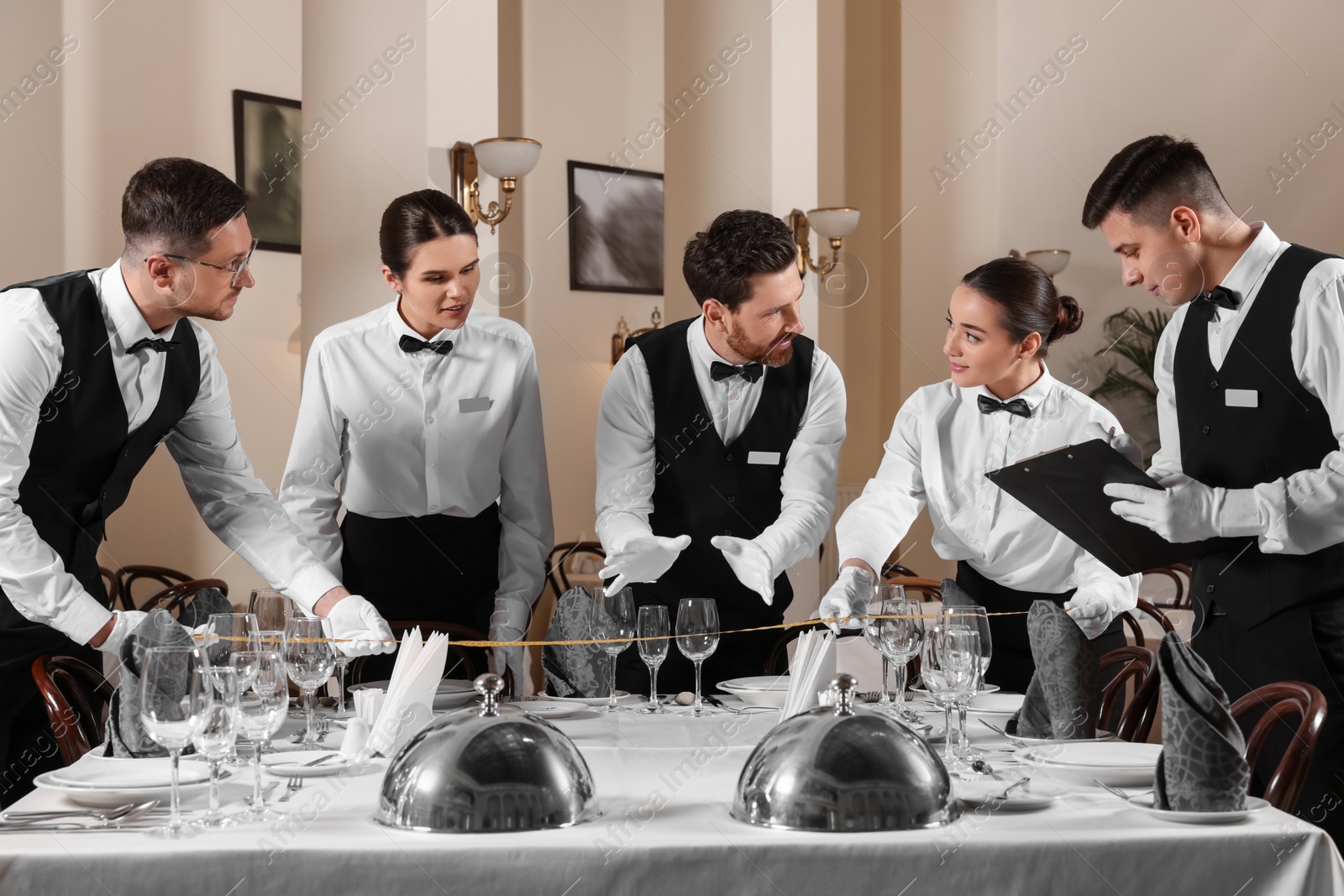 Photo of People setting table during professional butler courses in restaurant