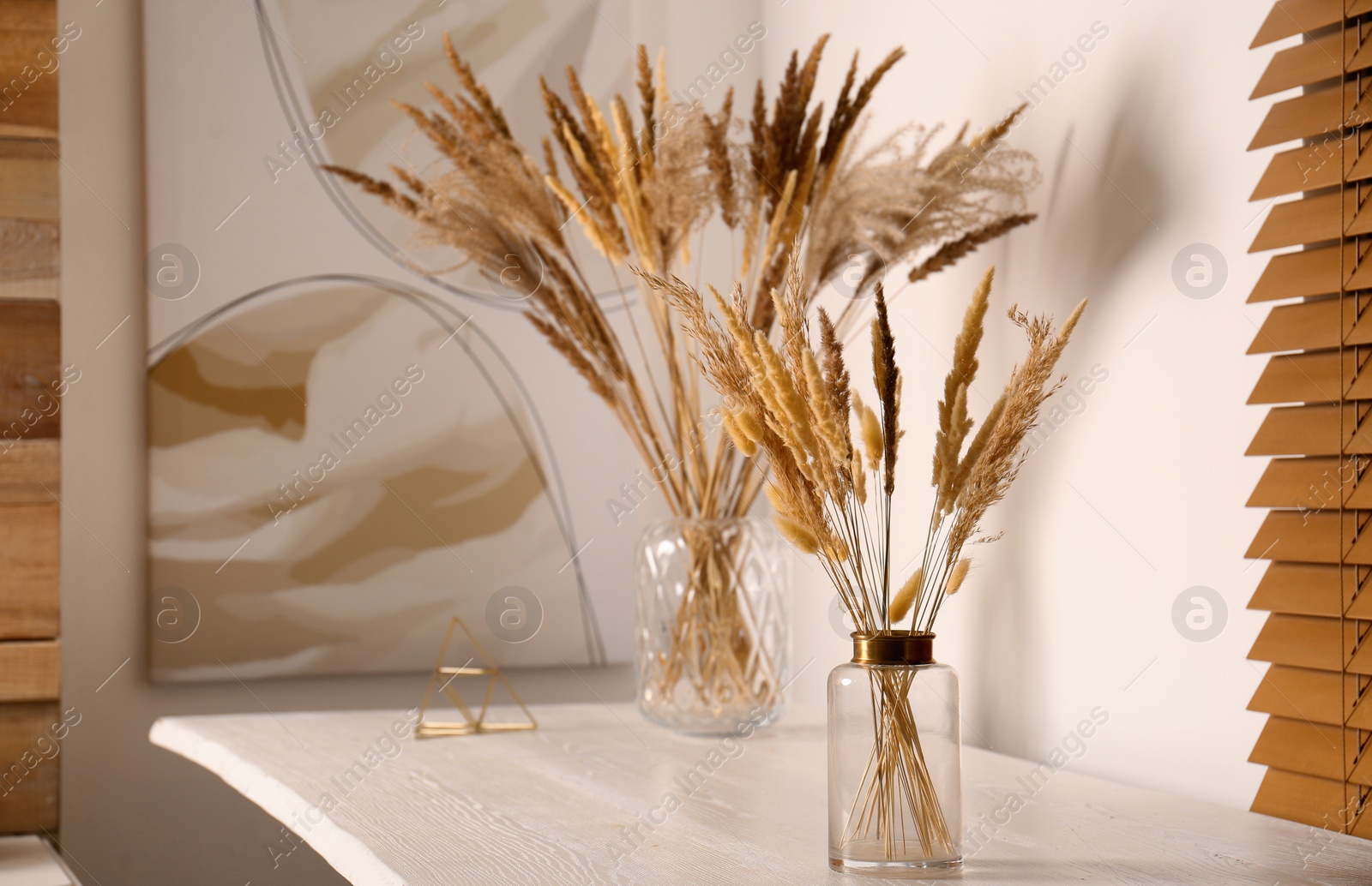 Photo of Dry plants on white table indoors. Interior design