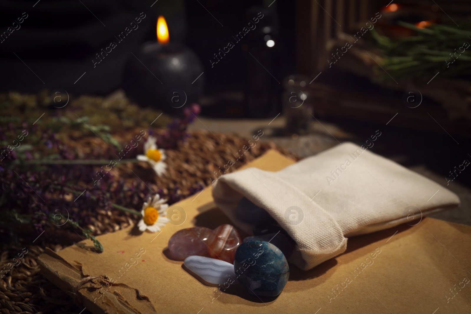 Photo of Bag with gemstones and healing herbs on table