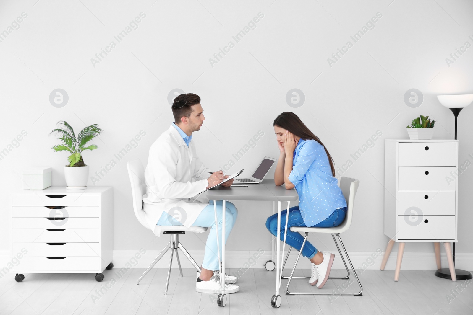 Photo of Depressed young woman having appointment with psychologist in office