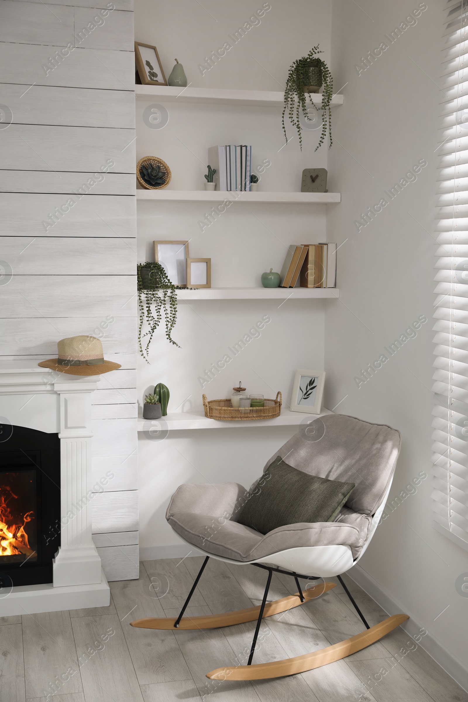 Photo of Many shelves with different decor near fireplace in room. Interior design