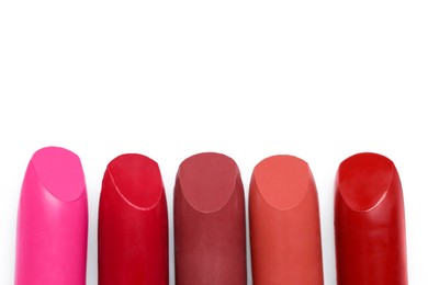 Photo of Many different bright lipsticks on white background, top view