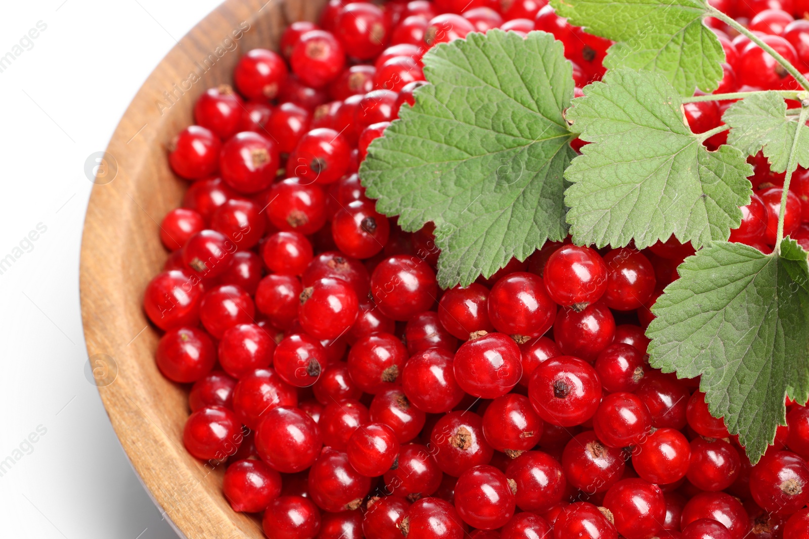 Photo of Tasty ripe red currant berries and green leaves in bowl, closeup. Space for text