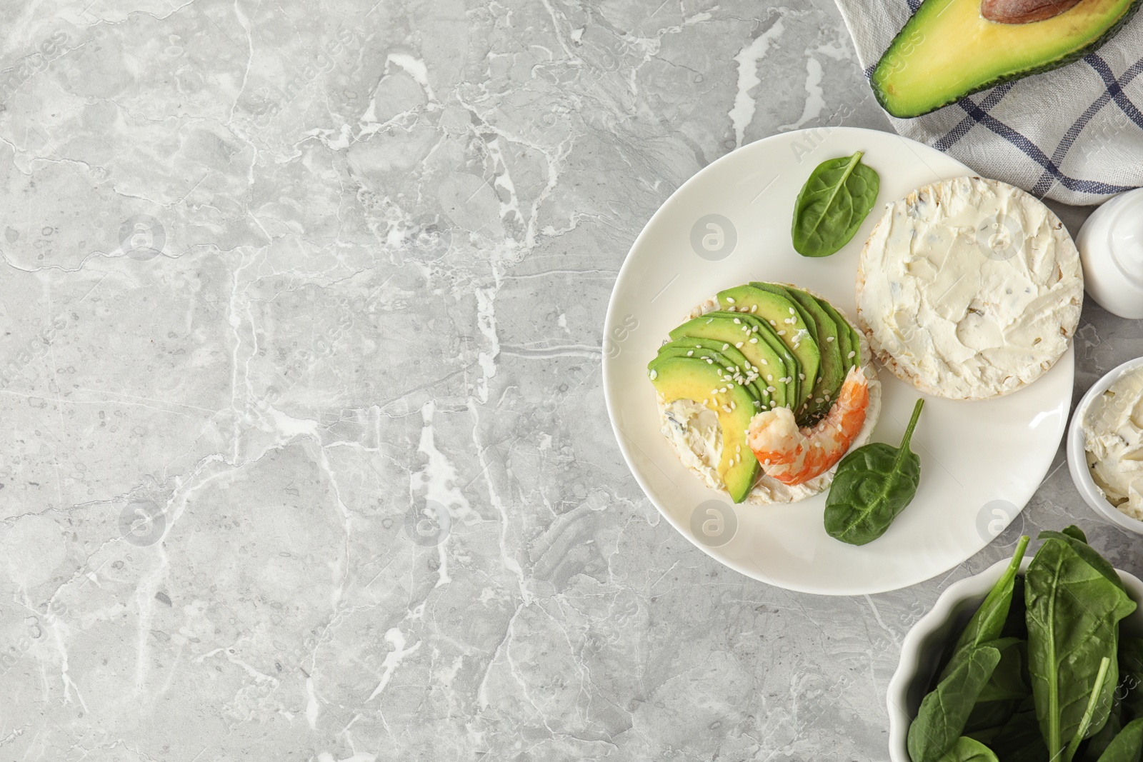 Photo of Puffed rice cake with shrimp and avocado served on grey marble table, flat lay. Space for text