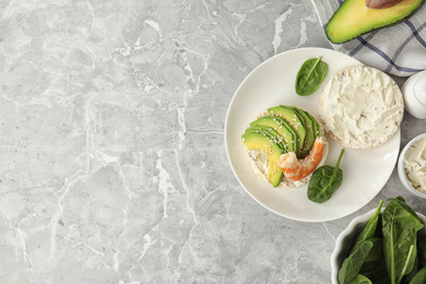 Puffed rice cake with shrimp and avocado served on grey marble table, flat lay. Space for text
