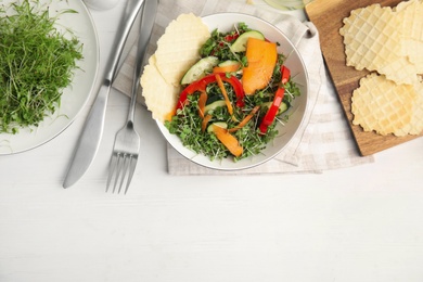 Delicious vegetable salad with microgreen served on white wooden table, flat lay. Space for text