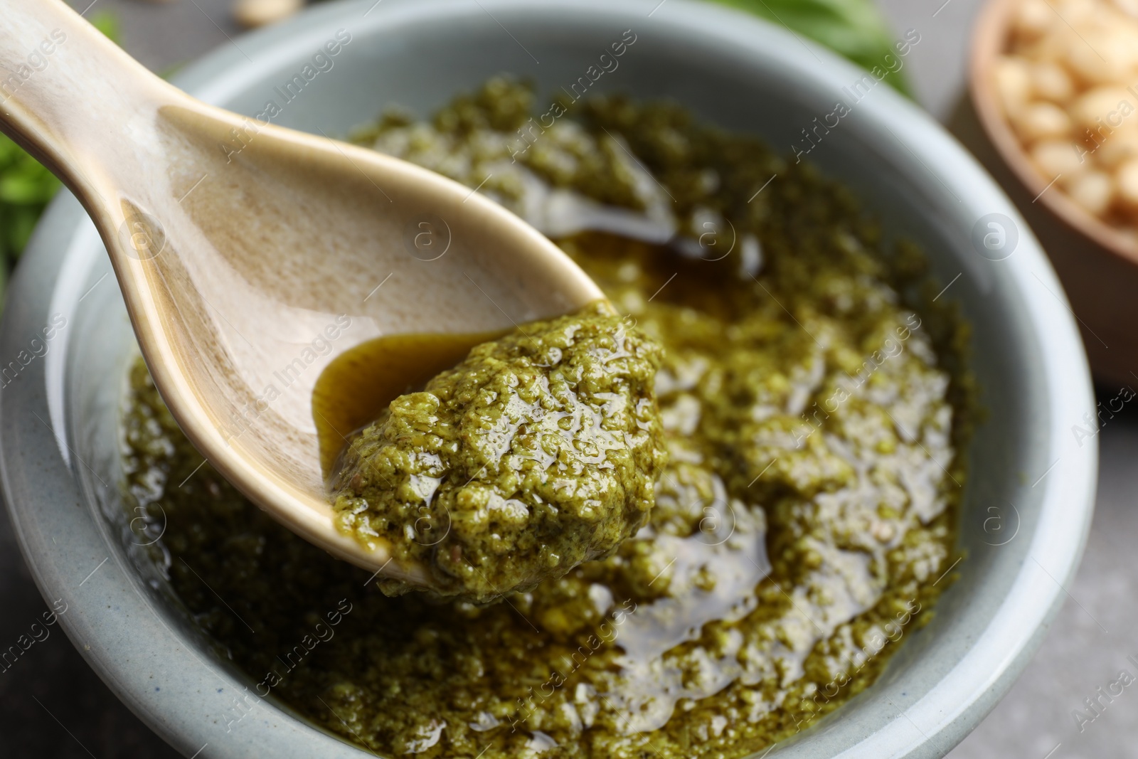 Photo of Taking tasty pesto sauce at table, closeup